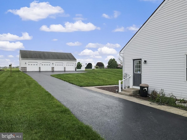 view of green lawn with a detached garage