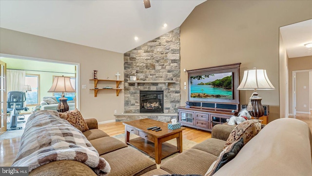 living room featuring lofted ceiling, a fireplace, wood finished floors, and baseboards