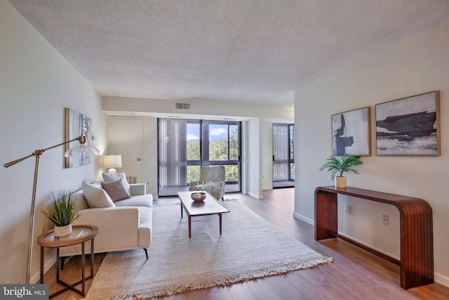 5300 Holmes Run Pkwy Unit 407, Alexandria, VA 22304 - living area featuring a textured ceiling, wood finished floors, and baseboards