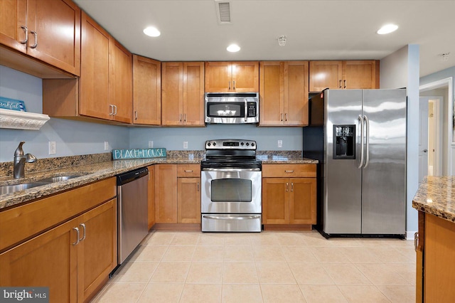 18 79th St Unit 403, Ocean City, MD 21842 - kitchen featuring appliances with stainless steel finishes, a sink, dark stone counters, brown cabinetry, and recessed lighting