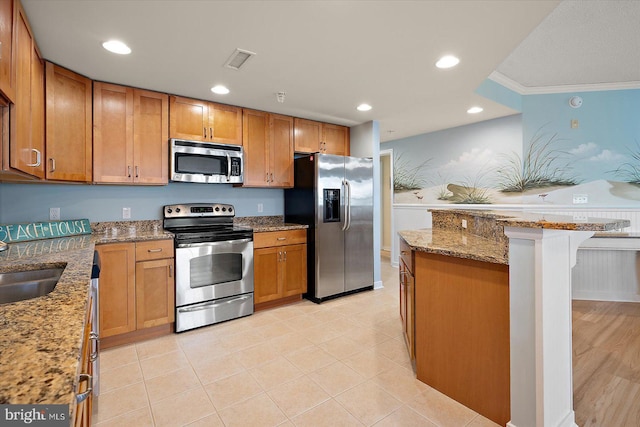 18 79th St Unit 403, Ocean City, MD 21842 - kitchen featuring appliances with stainless steel finishes, crown molding, light stone counters, brown cabinetry, and a sink