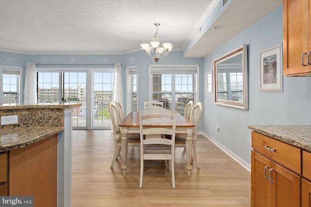 18 79th St Unit 403, Ocean City, MD 21842 - dining room with a chandelier, light wood-style floors, baseboards, a textured ceiling, and crown molding