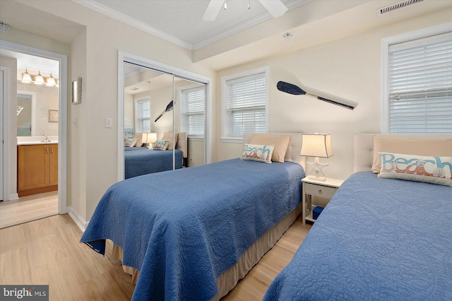 18 79th St Unit 403, Ocean City, MD 21842 - bedroom with ornamental molding, light wood-style flooring, a sink, ceiling fan, and a closet