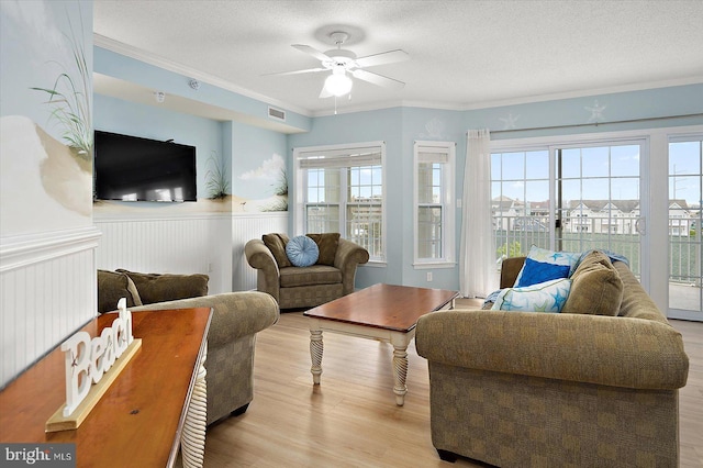 18 79th St Unit 403, Ocean City, MD 21842 - living room featuring wood finished floors, a ceiling fan, a wainscoted wall, a textured ceiling, and crown molding