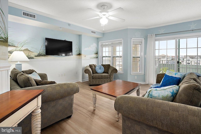 18 79th St Unit 403, Ocean City, MD 21842 - living room featuring light wood finished floors, a ceiling fan, a wainscoted wall, and ornamental molding