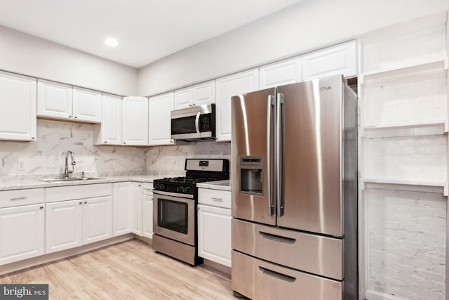 2012 Eagle St, Baltimore, MD 21223 - kitchen with white cabinets, appliances with stainless steel finishes, decorative backsplash, and a sink