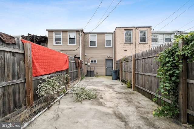 2012 Eagle St, Baltimore, MD 21223 - rear view of house featuring a fenced backyard, concrete driveway, cooling unit, and a patio area