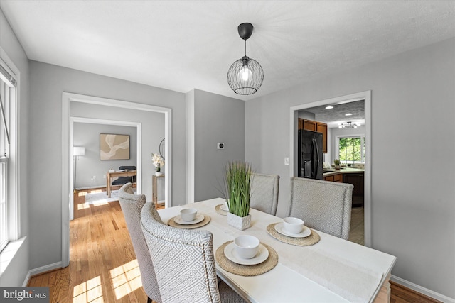 dining room featuring light wood-style floors and baseboards