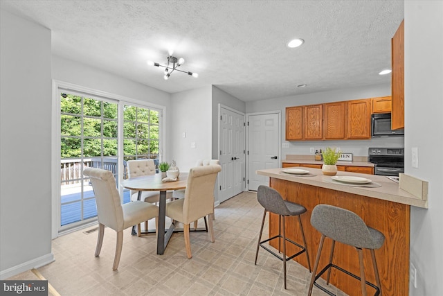 dining area with light floors, baseboards, a textured ceiling, and recessed lighting