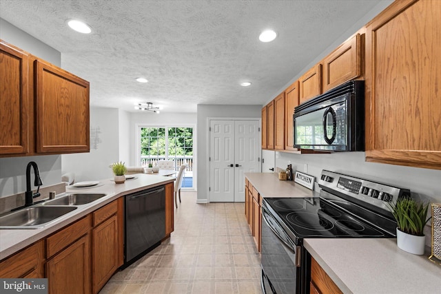 kitchen featuring black appliances, a sink, light floors, light countertops, and brown cabinets