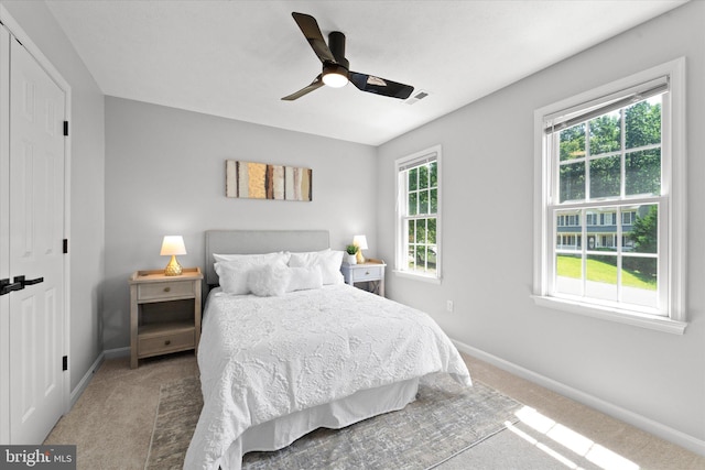 carpeted bedroom featuring baseboards and a ceiling fan