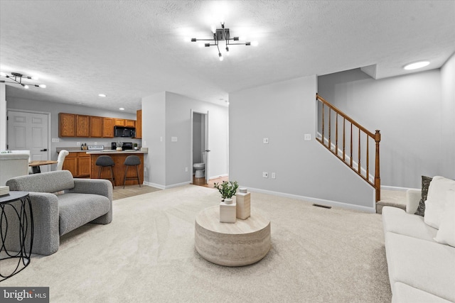 living room featuring light colored carpet, stairway, baseboards, a textured ceiling, and recessed lighting