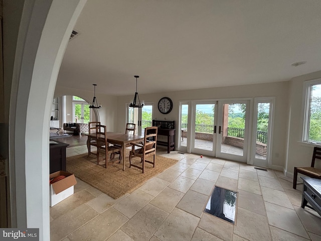 11500 Springridge Rd, Potomac, MD 20854 - dining room featuring healthy amount of natural light, arched walkways, stone tile flooring, and a chandelier