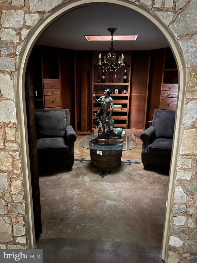11500 Springridge Rd, Potomac, MD 20854 - sitting room with arched walkways, unfinished concrete floors, and a chandelier