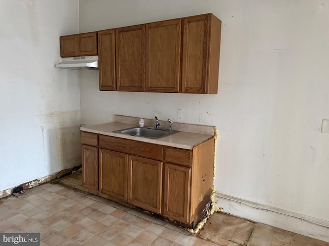531 N 63rd St, Philadelphia, PA 19151 - kitchen featuring brown cabinets, a sink, light countertops, light floors, and under cabinet range hood