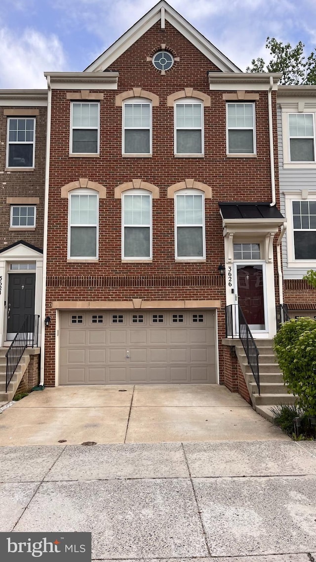view of property featuring an attached garage, driveway, and brick siding