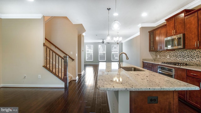 kitchen featuring a sink, appliances with stainless steel finishes, a kitchen island with sink, tasteful backsplash, and dark wood-style flooring