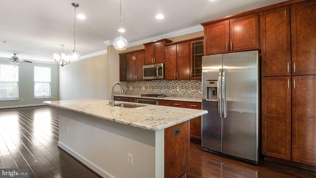 kitchen featuring appliances with stainless steel finishes, a sink, dark wood finished floors, decorative backsplash, and a kitchen island with sink
