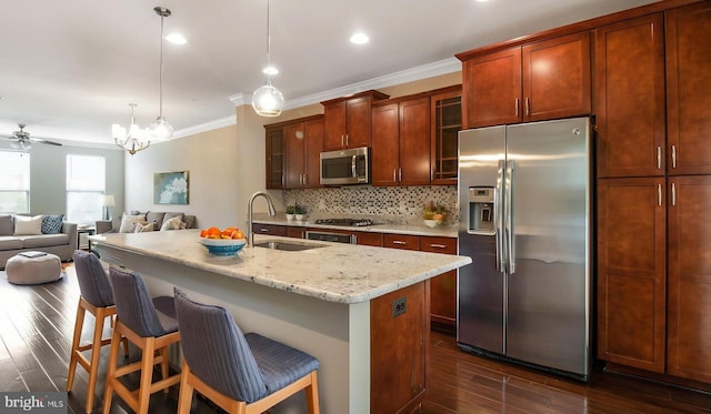 kitchen with appliances with stainless steel finishes, a sink, dark wood finished floors, ornamental molding, and decorative backsplash