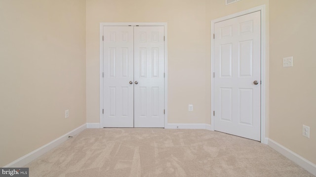 unfurnished bedroom with carpet flooring, a closet, and baseboards