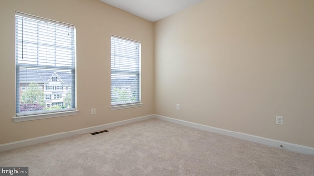 carpeted spare room featuring baseboards