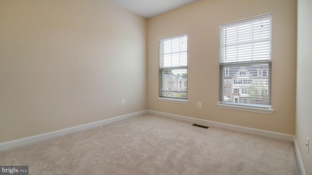 unfurnished room with plenty of natural light, carpet flooring, and baseboards