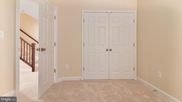 unfurnished bedroom featuring carpet flooring, a closet, and baseboards