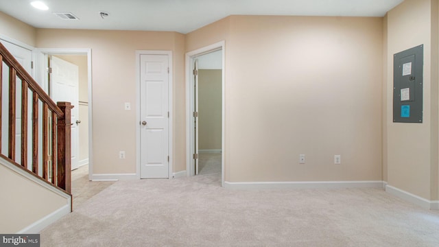 carpeted empty room with electric panel, stairway, and baseboards