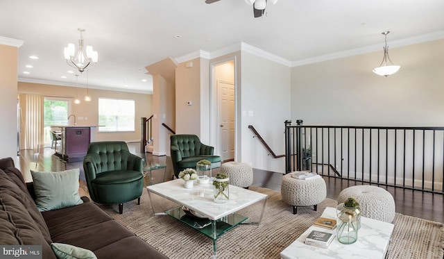 living room with wood finished floors, a chandelier, ornamental molding, a ceiling fan, and recessed lighting