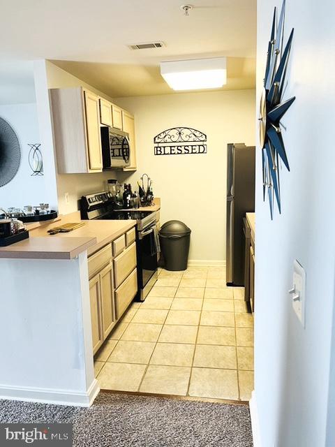9000 Bay Ave Unit 209, North Beach, MD 20714 - kitchen with appliances with stainless steel finishes, light tile patterned flooring, light countertops, and light brown cabinets