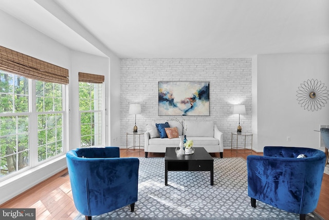 2505 Wheat Meadow Ct, Herndon, VA 20171 - living area with healthy amount of natural light, wood finished floors, and brick wall