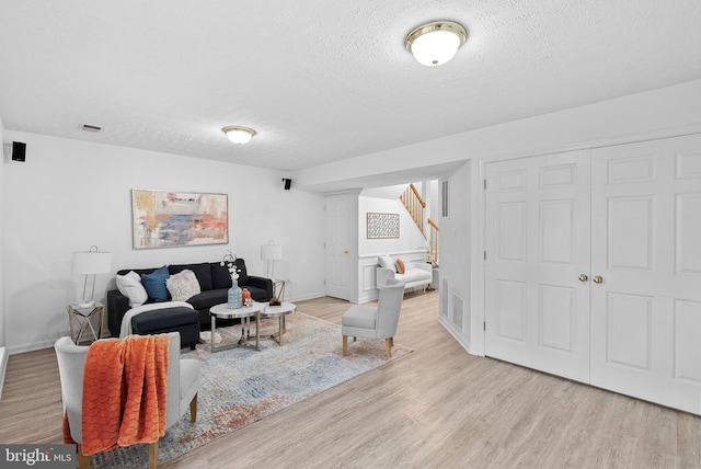 2505 Wheat Meadow Ct, Herndon, VA 20171 - living area featuring wood finished floors, stairway, a textured ceiling, and baseboards