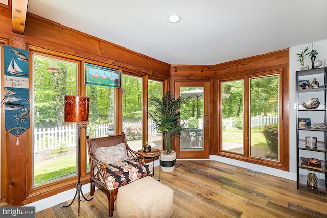 sunroom featuring wooden walls, hardwood / wood-style floors, visible vents, and recessed lighting