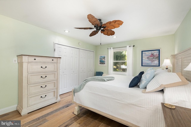 bedroom featuring light wood finished floors, a closet, baseboards, and recessed lighting