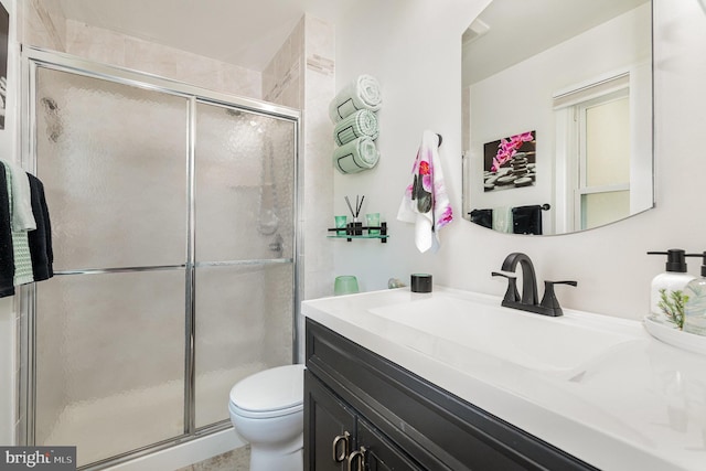 full bathroom with vanity, toilet, and a shower stall