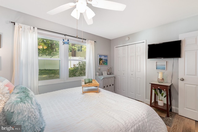 bedroom with a ceiling fan, baseboards, a closet, and wood finished floors