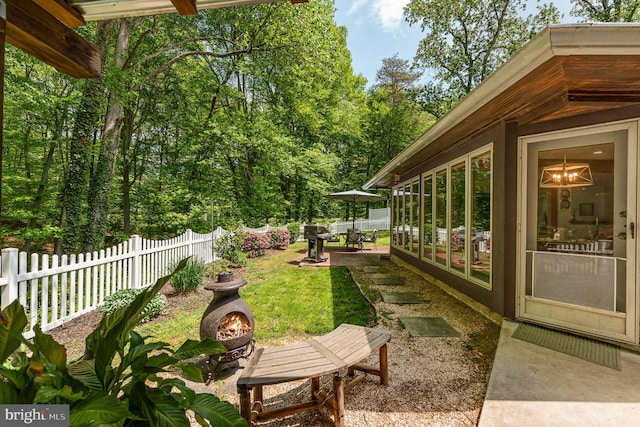 view of yard featuring an outdoor fire pit, a patio area, and fence