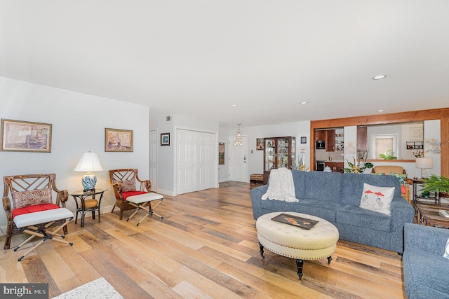 living room featuring light wood-style flooring, baseboards, and recessed lighting