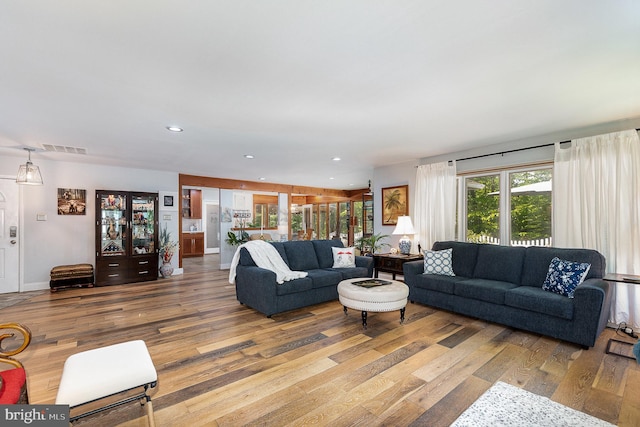living area featuring visible vents, wood finished floors, and recessed lighting