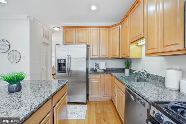 kitchen featuring appliances with stainless steel finishes, a sink, light wood-style floors, stone countertops, and recessed lighting