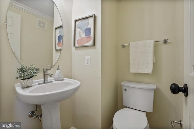 bathroom with toilet and ornamental molding
