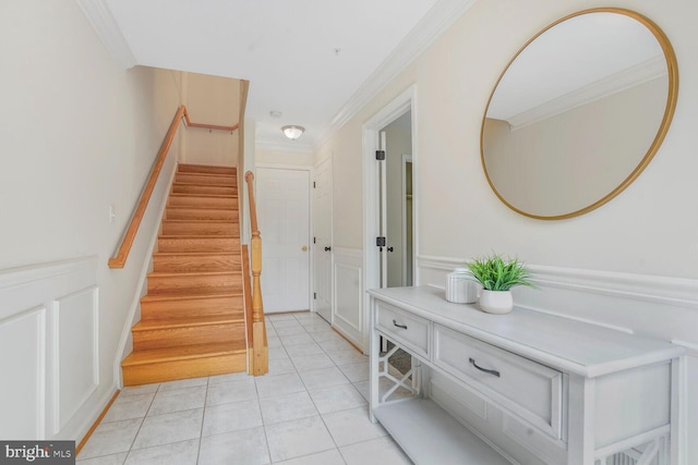 stairway with crown molding and tile patterned flooring