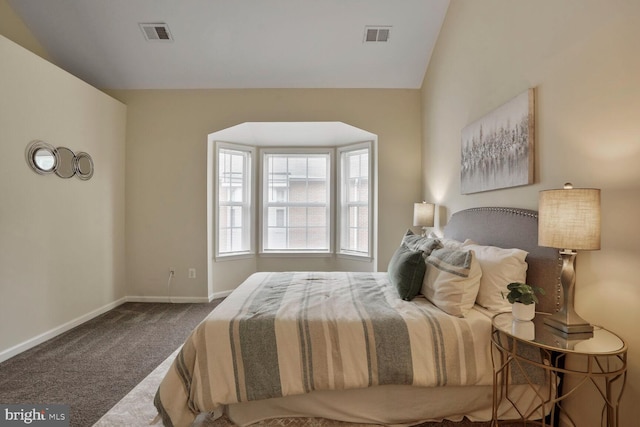 carpeted bedroom featuring baseboards, lofted ceiling, and arched walkways