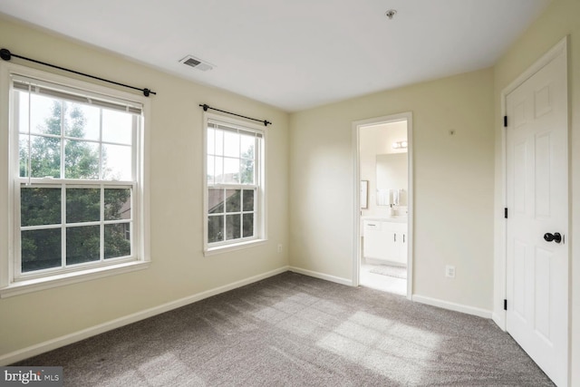 unfurnished bedroom featuring baseboards, carpet flooring, and connected bathroom