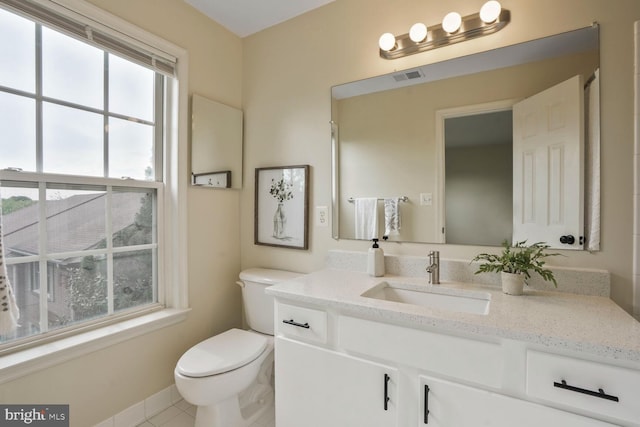 bathroom featuring plenty of natural light, toilet, vanity, and tile patterned floors