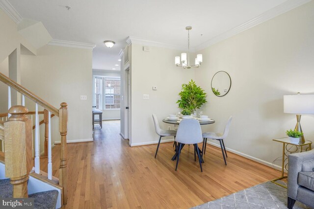 dining room featuring ornamental molding, a chandelier, light wood-style flooring, stairs, and baseboards