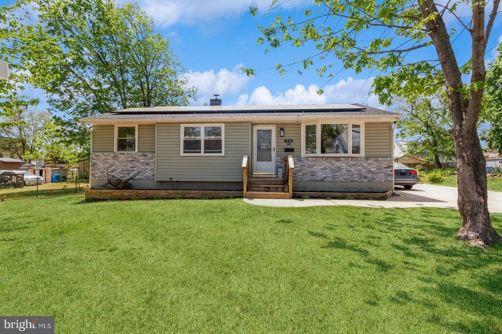 514 Asbury Ave, National Park, NJ 08063 - ranch-style home featuring a front lawn, a chimney, brick siding, and solar panels