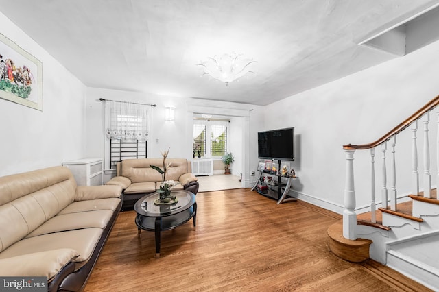 living room with wood finished floors, stairs, and baseboards