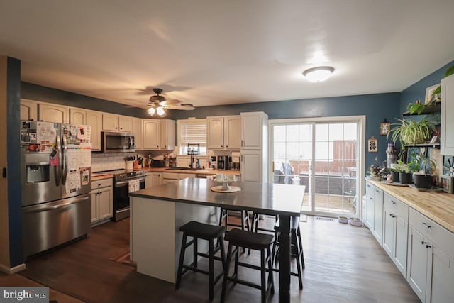 230 Jewel Dr, York, PA 17404 - kitchen featuring appliances with stainless steel finishes, tasteful backsplash, a sink, ceiling fan, and dark wood-style flooring