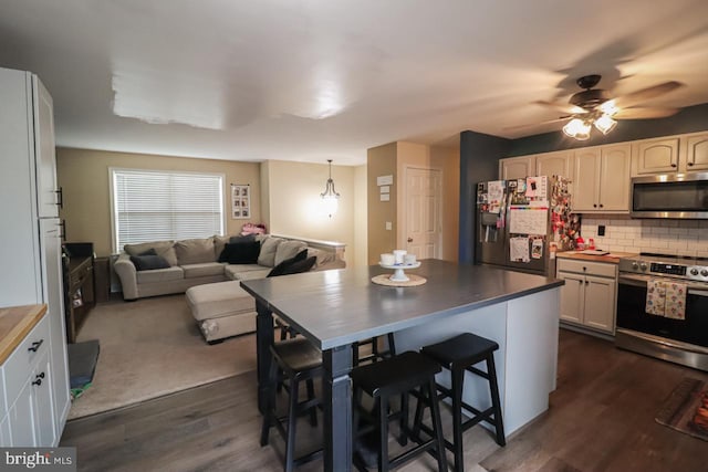 230 Jewel Dr, York, PA 17404 - kitchen with appliances with stainless steel finishes, decorative backsplash, open floor plan, dark wood-type flooring, and ceiling fan